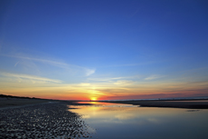 Ameland-Holland<br />Der glühende Sonnenuntergang wirft tiefe Schatten auf dem nördlichen Seestrand von Ameland.