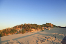 Juist-Töwerland: Eindrucksvoll wirft die untergehende Sonne vor der Dunkelheit noch lange Schatten auf dem Strand.