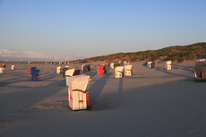 Juist-Töwerland: Eindrucksvoll wirft die untergehende Sonne vor der Dunkelheit noch lange Schatten auf dem Strand.