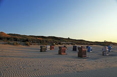 Juist-Töwerland: Eindrucksvoll wirft die untergehende Sonne vor der Dunkelheit noch lange Schatten auf dem Strand.