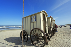 Norderney: DIE Thalassoinsel. Oststrand Weiße Düne. Badekarren aus Holz, auf zwei oder vier Rädern, dienen heute noch als Umkleidekabinen für die Strandbesucher.