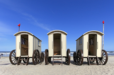 Norderney: DIE Thalassoinsel. Oststrand Weiße Düne. Badekarren aus Holz, auf zwei oder vier Rädern, dienen heute noch als Umkleidekabinen für die Strandbesucher.