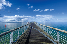 Scharbeutz - Niendorf. Schwere Wolken hängen über die Niendorfer Seebrücke.