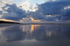 Wangerooge: Das letzte Sonnenuntergangslicht spiegelt sich im Wasser.