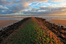 Wangerooge: Glühender Sonnenaufgang über die aufgewühlte Nordsee..